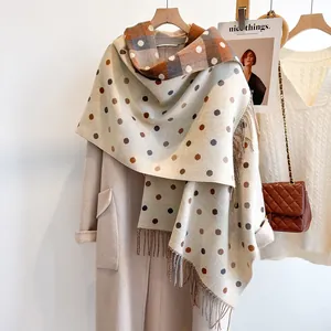 Detail of cashmere-like scarf with polka dots, plaid pattern and fringe tassels