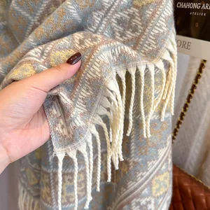 Dettaglio di sciarpa a quadri in morbido cashmere con bordi a frange color avorio