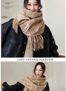 Detailed close-up of light brown plaid scarf with fringe tassels and soft knitted texture