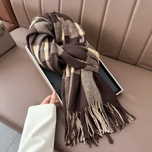 Close-up of thick plaid shawl with fringe detail in brown and cream cashmere-style fabric