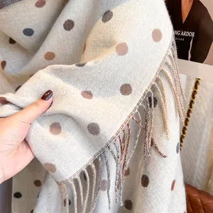 Close-up of beige pashmina shawl with dark dots and soft fringe edges for winter
