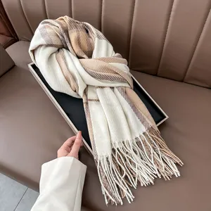 Close-up of plaid winter scarf with fringe details on a brown leather texture background