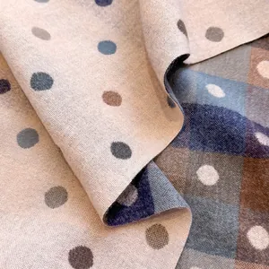 Close-up of double-sided polka dot and plaid cashmere scarf showing fabric texture