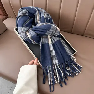 Detail of navy and cream tartan scarf with soft fringe on an elegant display tray