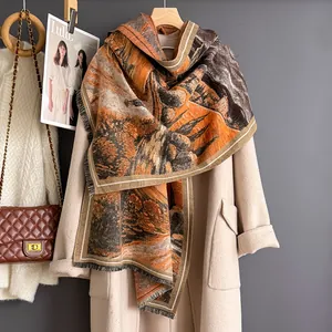 Détail de l'écharpe à imprimé paysage artistique avec franges sur un manteau beige