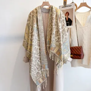 Detailed macro view of vintage paisley floral scarf with long tassels on a wooden hanger