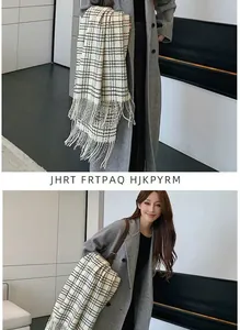 Detailed close-up of a classic black and white plaid scarf with long tassels for winter