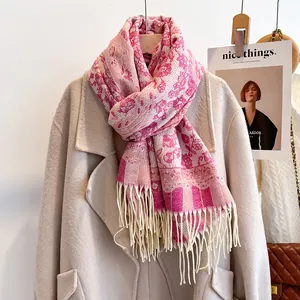 Close-up of pink floral jacquard pattern and long tassels on a warm winter scarf
