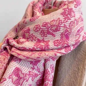 Detailed view of floral jacquard patterns on thick pink and beige pashmina scarf