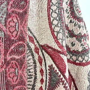 Macro detail of bordeaux red paisley jacquard fabric on a warm cashmere shawl