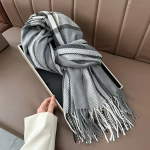 Close-up of thick plaid tassel scarf texture neatly folded on an elegant black tray