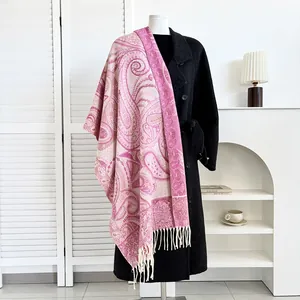 Detail of pink paisley cashmere-like scarf draped over a black winter wool coat