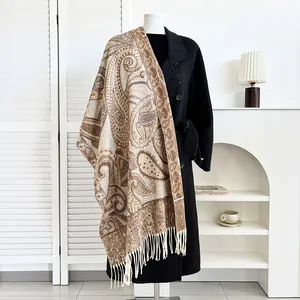 Detail of paisley pattern pashmina shawl with tassel fringe on black winter coat