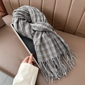 Detailed texture of gray and brown plaid cashmere scarf with long fringe in a gift box
