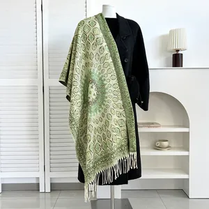 Close-up of ethnic style cashmere scarf with green geometric patterns and tassel fringe