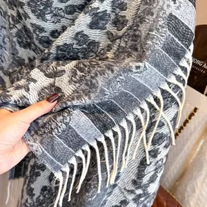 Close-up of soft thick ethnic floral scarf showing grey woven texture and white fringe