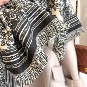 Close-up of black and white Toile de Jouy cashmere feel scarf with fringe detail