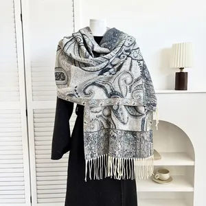 Close-up of paisley pattern pashmina shawl with tassel fringe on a white mannequin