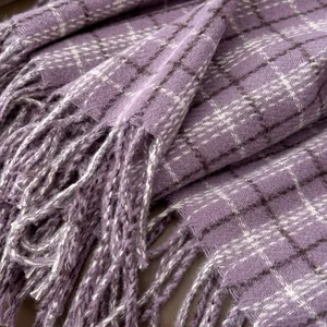 Close-up of purple plaid cashmere scarf showing soft texture and fringe details