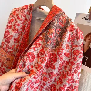 Detail of floral jacquard knit shawl showing thick texture and orange ethnic patterns