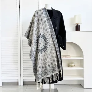 Close-up of ethnic style printed scarf with fringe detail on a black coat display