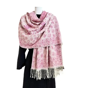 Pink and white bohemian cashmere scarf with fringe tassels shown on a black coat
