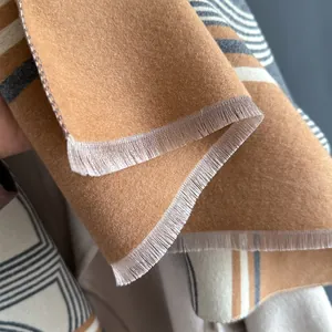 Dettaglio di sciarpa morbida effetto cashmere con motivi geometrici e frange raffinate