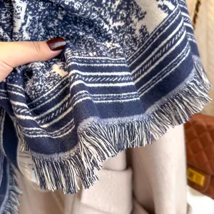 Detail of blue and white floral printed scarf with fringe edges and soft texture