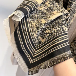 Detail of soft black and beige pashmina shawl with floral patterns and fine tassels