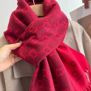 Gros plan d'une écharpe jacquard rouge foncé avec motif entrelacé et franges