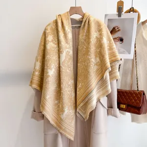 Detail of ginger toile de jouy cashmere shawl with fringe on beige coat