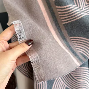 Dettaglio della sciarpa reversibile con spessa trama in cashmere e bordo con frange