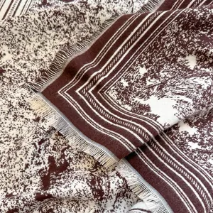 Macro shot of double-sided floral pattern shawl with soft cashmere-like fringe detail