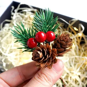 Detail von Weihnachtsdeko mit Zapfen, Kiefernnadeln und roten Beeren für Geschenkverpackungen