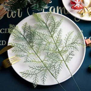 Pair of artificial PE cedar branches on a white plate with Christmas holiday decor