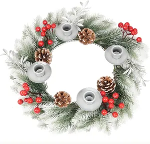Close-up of a frosted Christmas wreath candle holder with red berries and pine cones