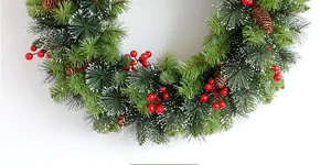 Detail of Christmas wreath featuring red berries, pine cones and snow-dusted needles