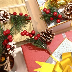 Mini Christmas pine needles pick with red berries and snowy pinecones on gift boxes
