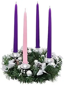 Detail of Advent wreath with pine needles, silver ribbons, and four tapered candles