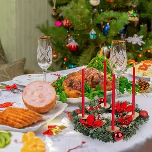 Dettaglio di un portacandele a ghirlanda natalizia con stelle di Natale e candele rosse