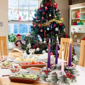 Close-up of Advent wreath with pine cones, red berries and four burning candles on a table