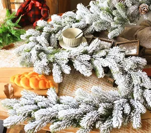 Detail of snowy PE pine garland with pinecones on a warm wooden tabletop setting