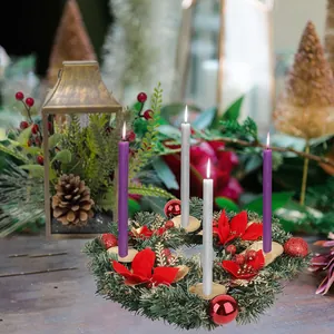 Dettaglio della ghirlanda natalizia con aghi di pino, stelle di Natale e quattro candele