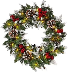 Detail of flocked Christmas wreath with warm LED lights, pine cones and red berries