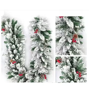 Detailed view of snowy Christmas garland with green needles, pine cones and red berries