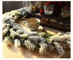 Macro detail of artificial PE Christmas garland with dense snow flocking and green pine needles