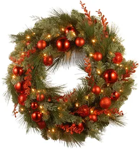 Detailed view of Christmas wreath with red berries, ornaments and warm LED lights