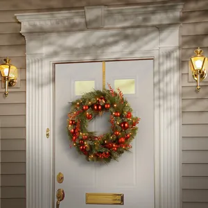 Detail of Christmas wreath with red ornaments and Happy Holidays gold door hanger hook