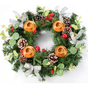 Christmas wreath candle holder with pine needles, red berries and gold metal cups