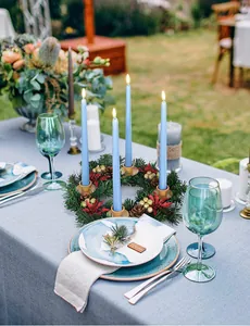 Centerpiece featuring a pine wreath with red berries and four blue taper candles